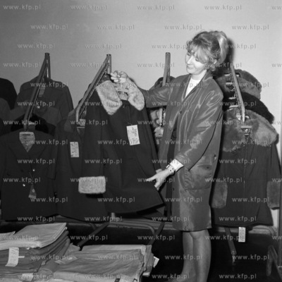 Sprzedawczyni w sklepie z odzieżą prezentuje zimowy...