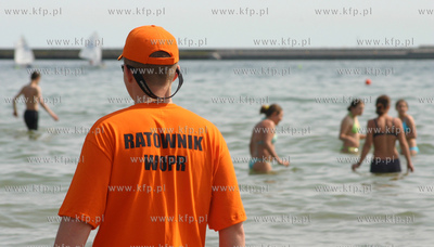 Ratownik pilnujacy plazowiczow kapiocych sie w morzu...