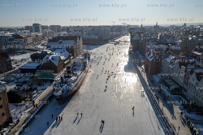 Spacerowicze na skutej lodem Motławie w Gdańsku....