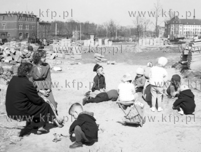 Matki z dziecmi bawia sie na placu Gorkiego, przed...