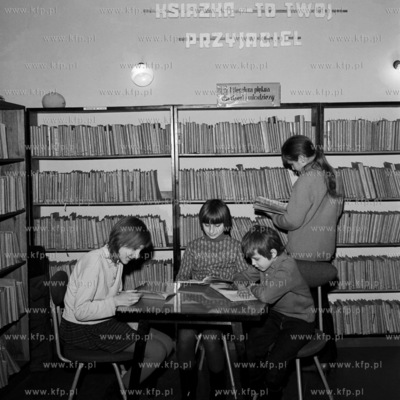 Młodzież przegląda ksiązki w bibliotece szkolnej....