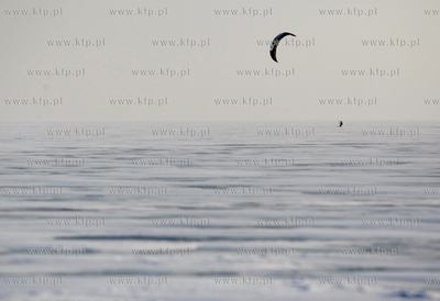 Kitesurfer slizga sie po zamarznietej zatoce puckiej....