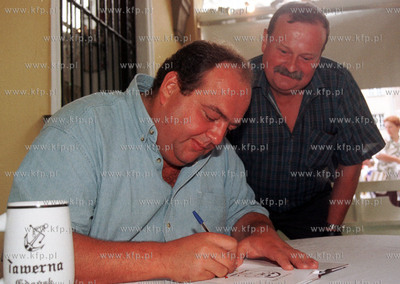 Maciej Kuron podpisuje swoja ksiazke na Dlugim Targu...