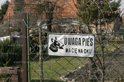Tabliczka ostrzegawcza przed groźnym psem wisząca...