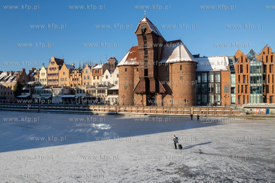 Spacerowicze na skutej lodem Motławie w Gdańsku....