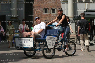 Aleksandra Mrozowska, wozi turystow riksza po starym...