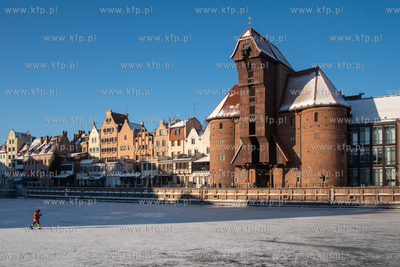 Spacerowicze na skutej lodem Motławie w Gdańsku....
