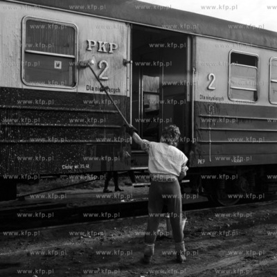 Pracownik koleji myje wagon Szybkiej Koleji Miejskiej....